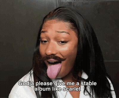 Woman With Fake Mustache Making Funny Face Saying Godja Please Give Me a Stable Album Like Scarlet