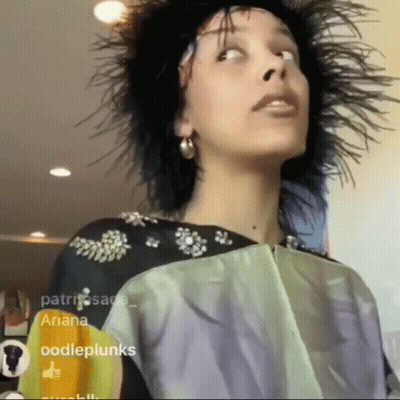 Woman With Feathers In Hair Looking Up GIF