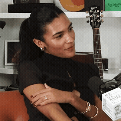 Woman With Gibson Guitar And Sign Saying And The World Wrote The Lyrics GIF