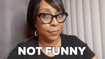 Woman With Glasses And Beanie Saying Not Funny GIF