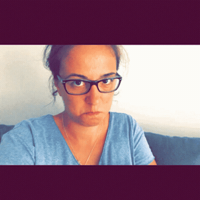 Woman With Glasses And Blue Shirt Looks Angry GIF