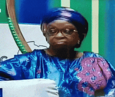 Woman With Glasses And Blue Shirt Sitting By Flag GIF