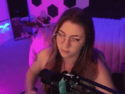 Woman With Glasses And Earrings Sitting At Microphone GIF