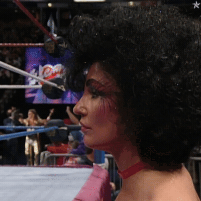 Woman With Glasses And Feathered Sleeves Saying Phe- GIF