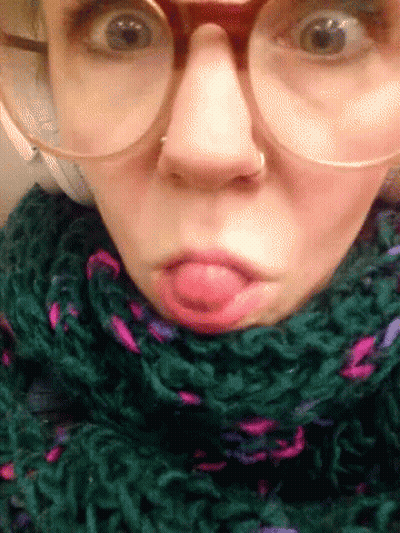 Woman With Glasses And Green Scarf Making Funny Face GIF