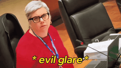 Woman With Glasses And Lanyard Evil Glare GIF