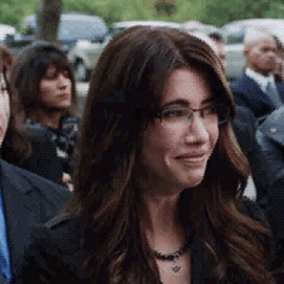 Woman With Glasses And Necklace In Crowd GIF