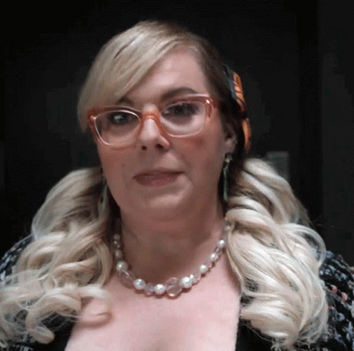 Woman With Glasses And Pearl Necklace Looking At Camera GIF