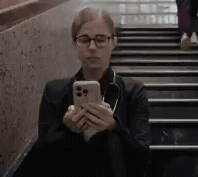 Woman With Glasses and Stethoscope Sitting on Stairs Looking at Phone