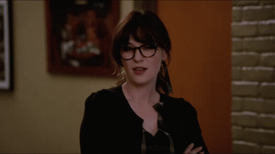 Woman With Glasses Arms Crossed In Front Of Painting GIF