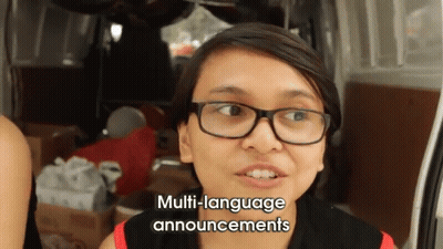 Woman With Glasses Giving Multi-Language Announcements By Van GIF