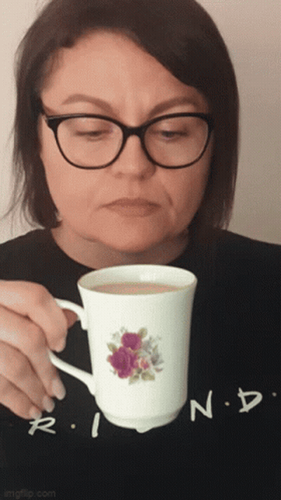 Woman With Glasses Holding Coffee Cup With Flower GIF