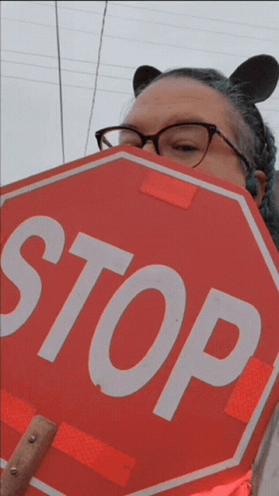 Woman With Glasses Holding Stop Sign GIF