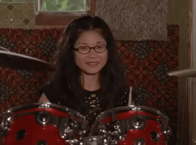 Woman With Glasses Playing Drum Set GIF