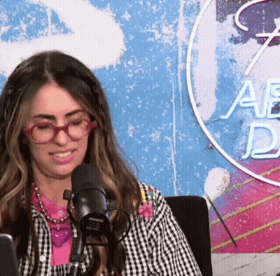 Woman With Glasses Sitting At Microphone In Studio GIF