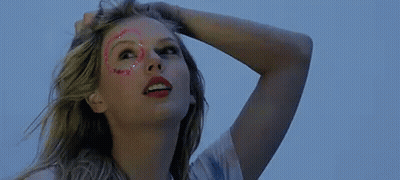 Woman With Glitter On Face Holding Hair Looking Up GIF