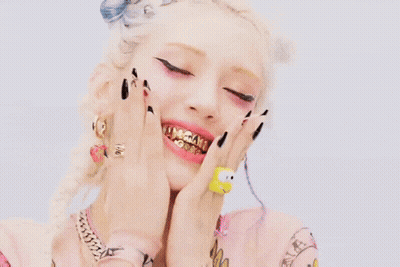 Woman With Gold Teeth And Hello Kitty Ring GIF