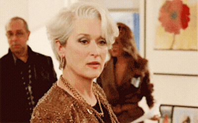 Woman With Gray Hair And Gold Necklace Standing In Front Of Group GIF