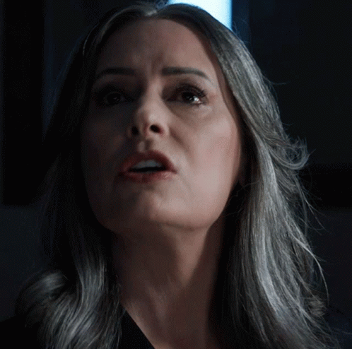 Woman With Gray Hair Looks Up At Camera GIF