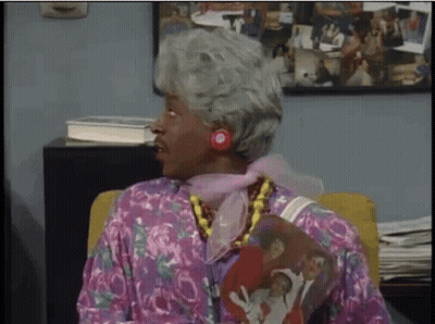 Woman With Gray Hair Sitting In Chair With Family Picture On Shirt GIF
