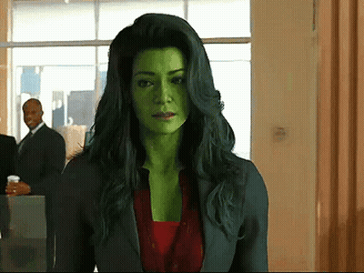 Woman With Green Hair And Green Face Standing In Hallway GIF