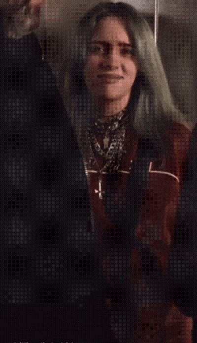 Woman With Green Hair In Red Jacket And Necklaces GIF