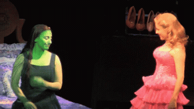 Woman With Green Paint Beside Woman In Pink Dress GIF