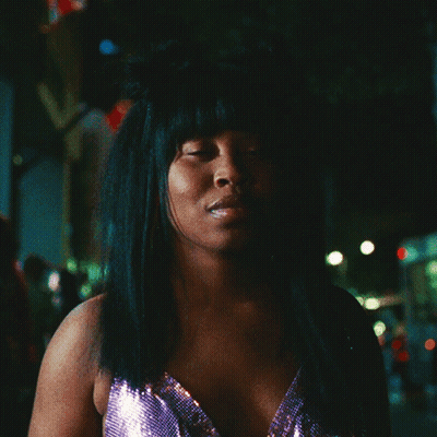 Woman With Hair Bun Looking At Camera GIF