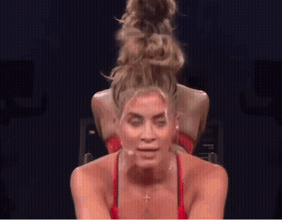 Woman With Hair Bun Riding Bike In Gym GIF
