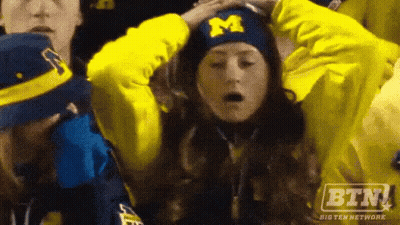 Woman With Hat With Letter M In Crowd GIF