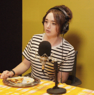 Woman With Headphones And Plate Of Food At Microphone GIF