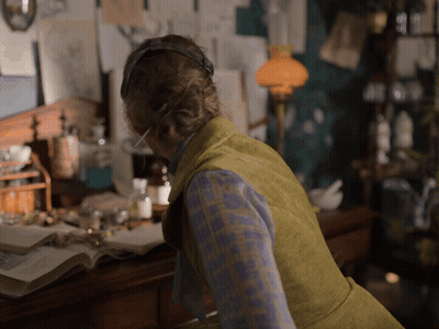 Woman With Headphones At Desk With Lamp GIF