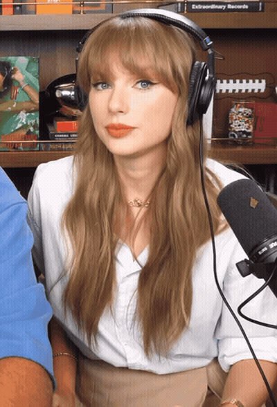 Woman With Headphones At Microphone In Front Of Bookshelf Saying Extraordinary Records GIF