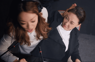 Woman With Headphones Beside Woman In Suit GIF