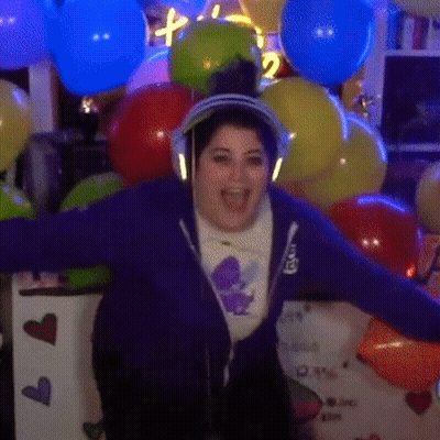 Woman With Headphones in Front of I Love You Sign and Balloons