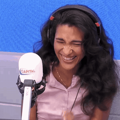 Woman With Headphones Laughing At Microphone Saying Capital GIF