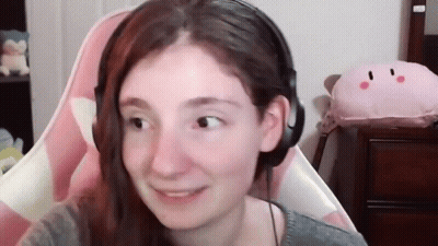 Woman With Headphones Smiling In Pink Chair GIF