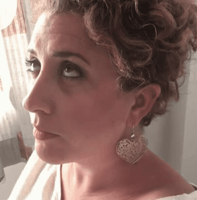 Woman With Heart-Shaped Earrings Looking At Camera GIF