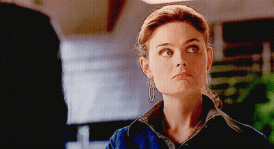 Woman With Hoop Earrings And Necklace Looking At Camera GIF