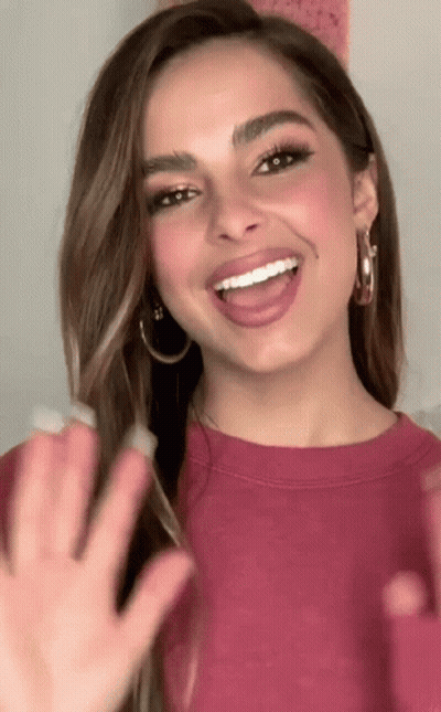 Woman With Hoop Earrings Smiling And Waving GIF