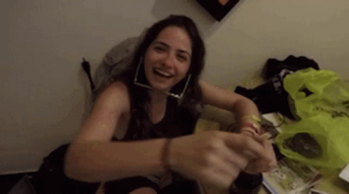 Woman With Hoop Earrings Smiling On Table GIF