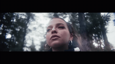 Woman With Hoop Earrings Standing In Woods GIF