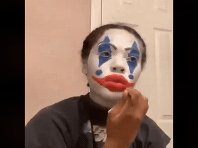 Woman With Joker Face Paint Applying Lipstick GIF