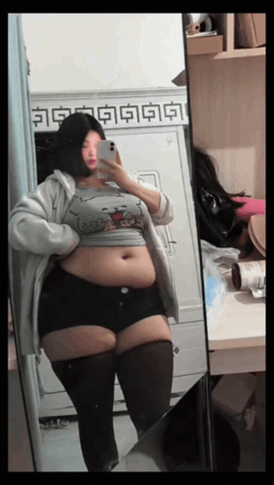 Woman With Large Belly In Front Of Mirror GIF