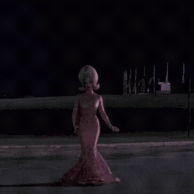 Woman With Large Wig And Swirl Shirt GIF