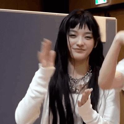 Woman With Long Black Hair and Bangs in White Sweater and Silver Necklace