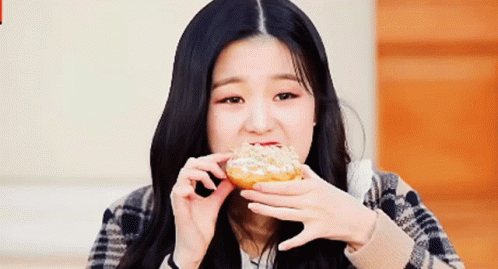 Woman With Long Black Hair Eating Donut GIF