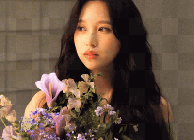 Woman With Long Black Hair Holding Flowers GIF