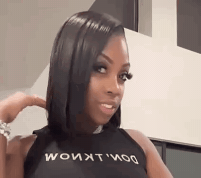 Mujer de pelo negro largo en top negro haciendo mueca GIF