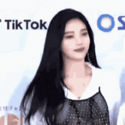 Woman With Long Black Hair In Front Of TikTok Wall GIF